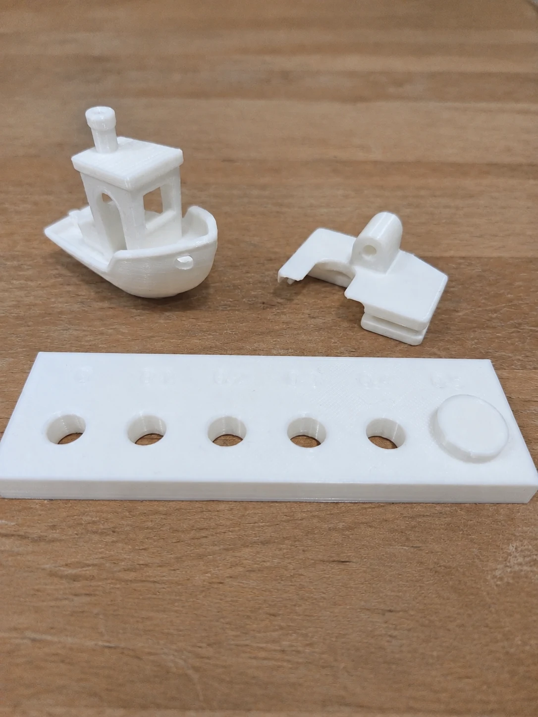 Three white printed test pieces on the shop workbench